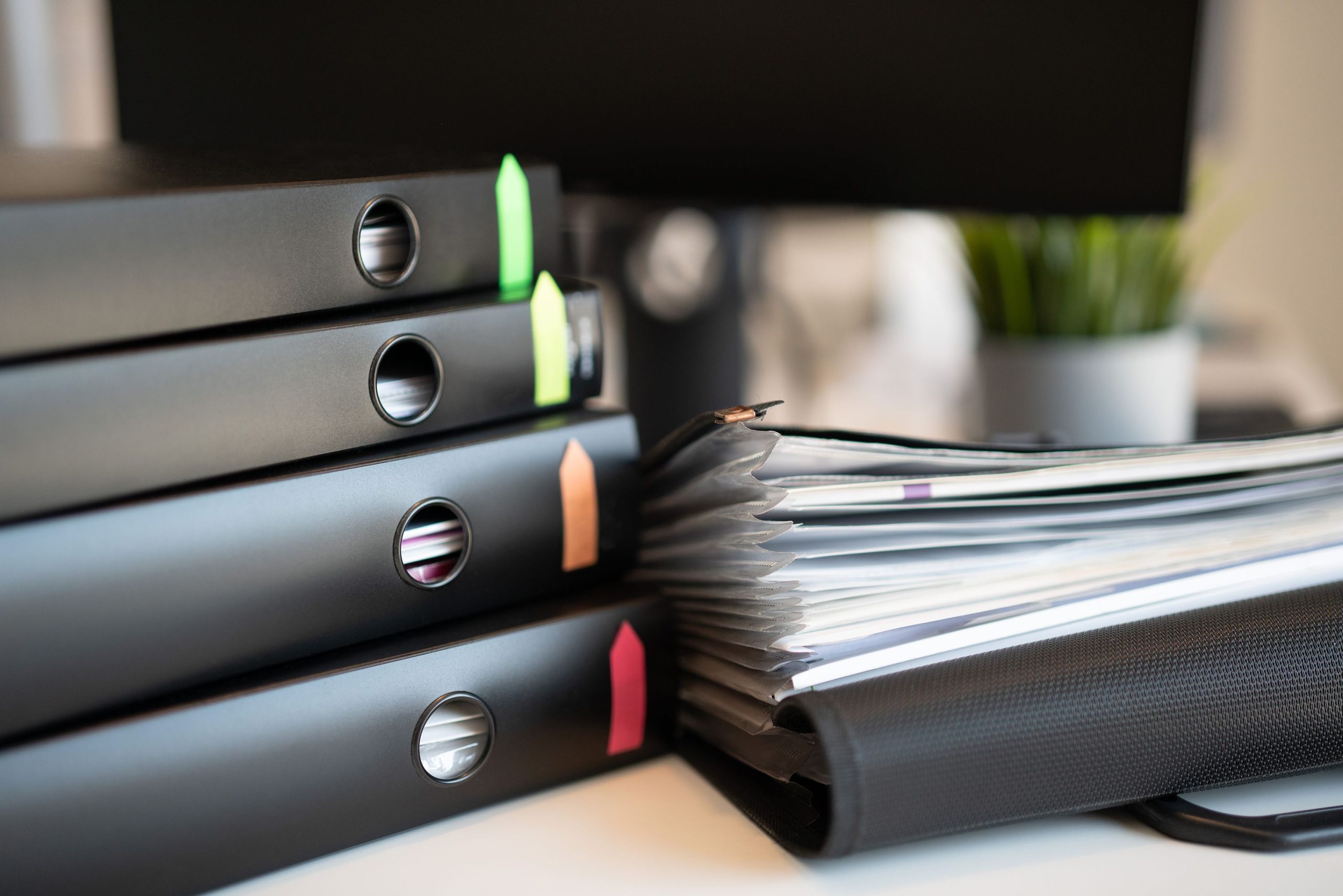 Pile de classeurs colorés sur un bureau moderne