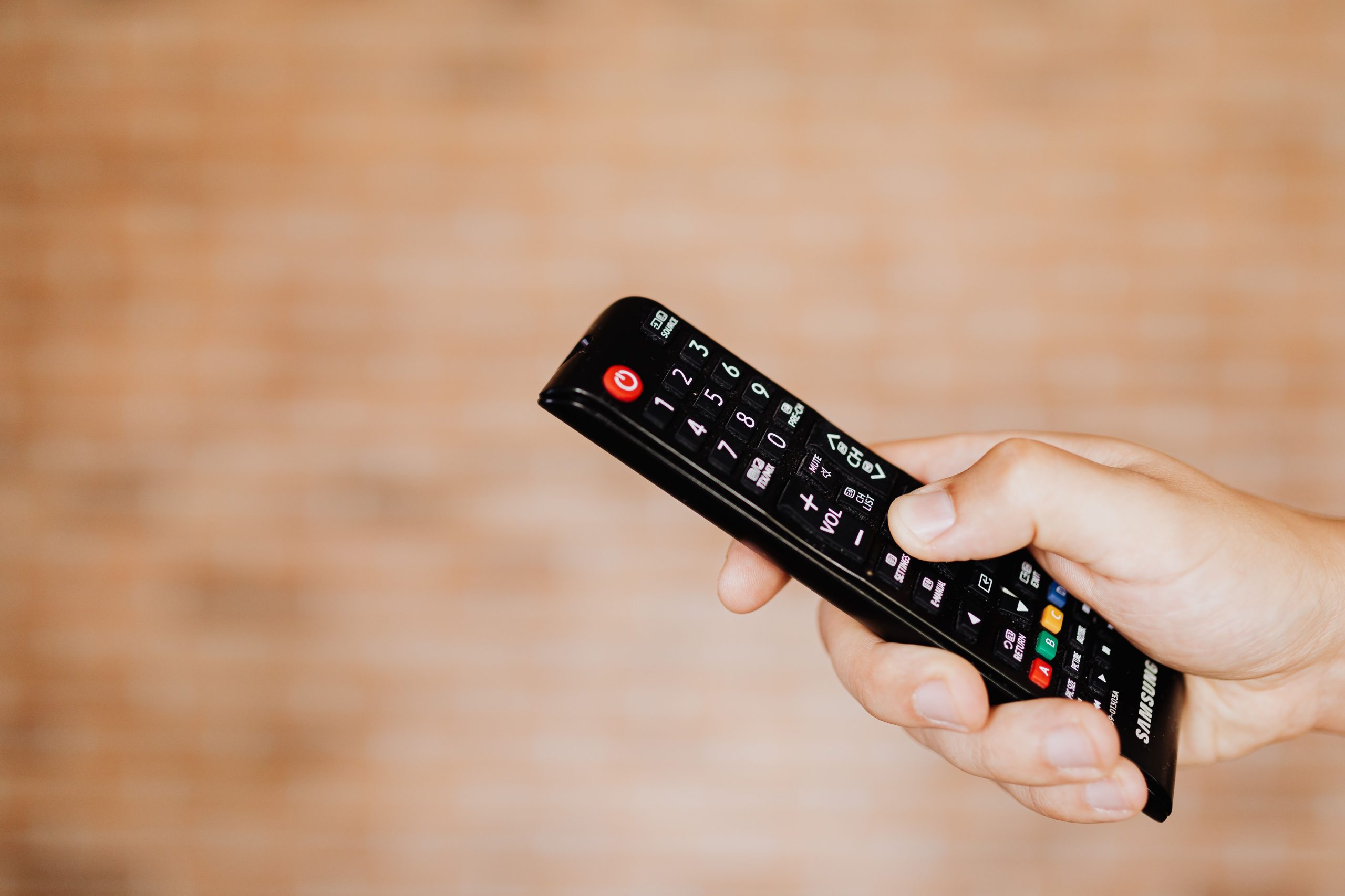 Gros plan main avec télécommande TV
