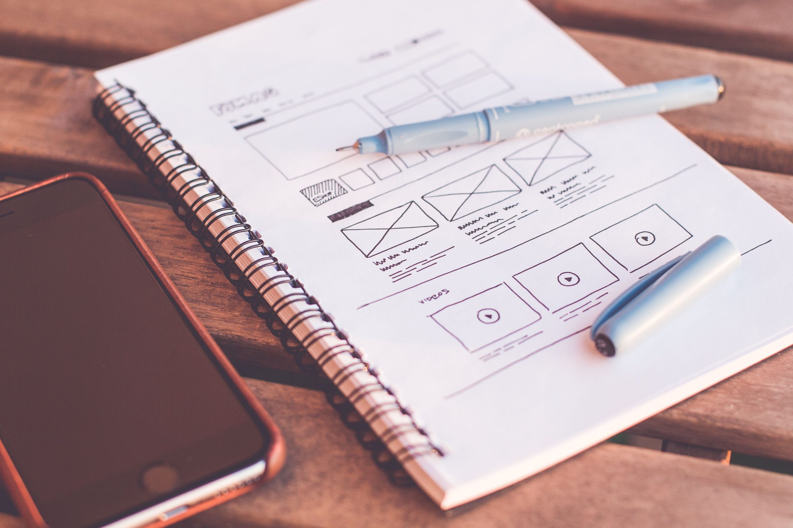 Carnet wireframes et smartphone bureau bois