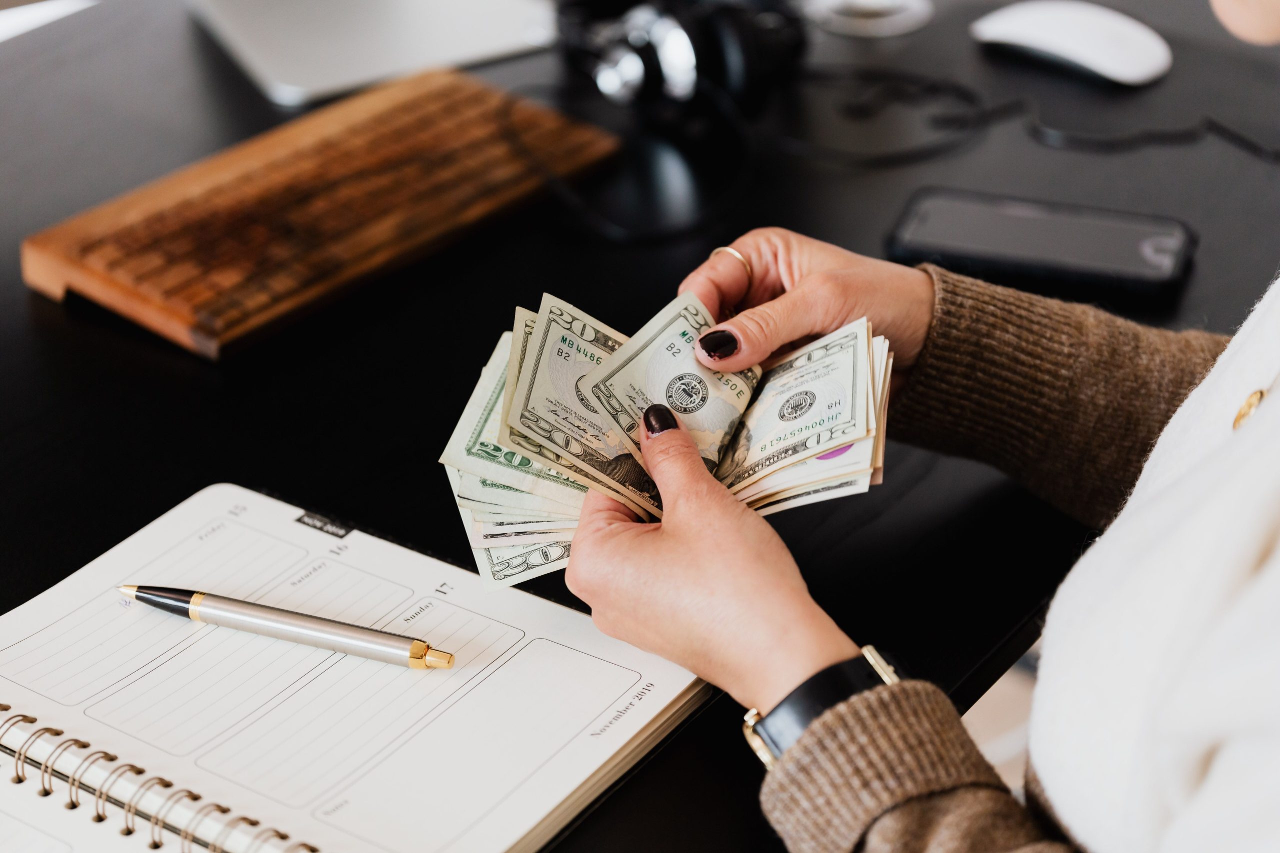 Femme comptant des billets à sa table de travail