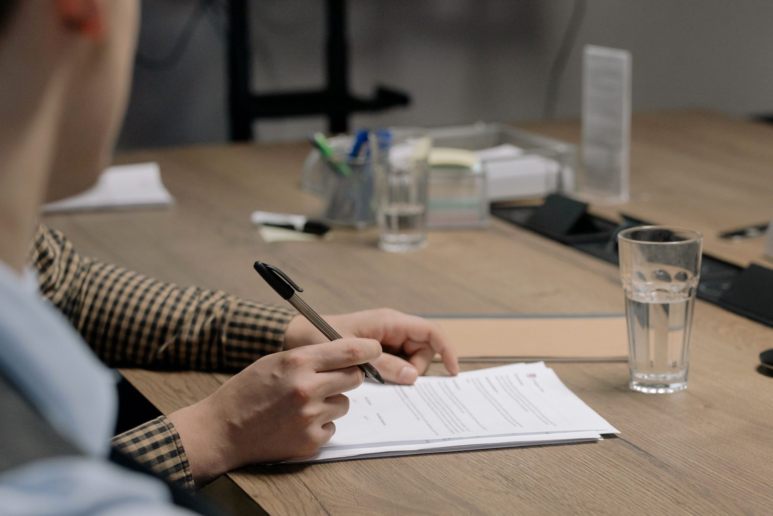 Personne signant un document sur une table en bois