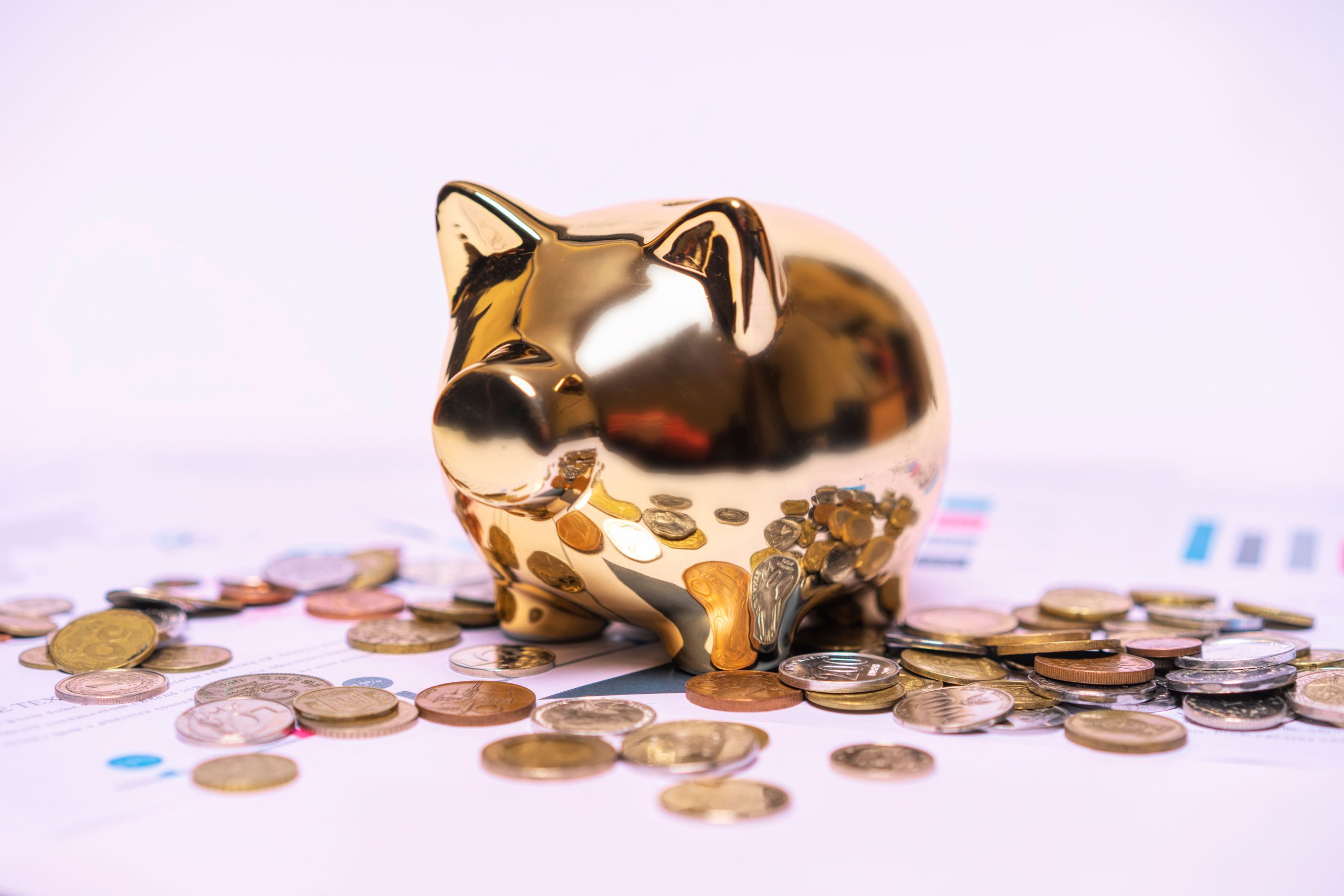 Tirelire dorée documents financiers pièces monnaies